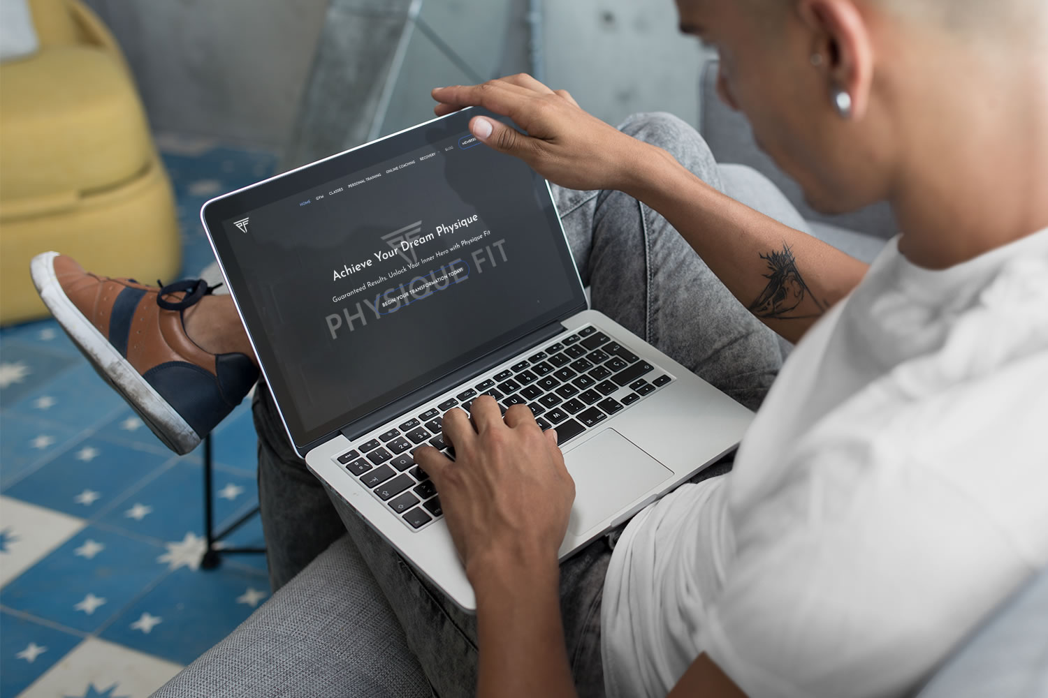person looking at the Physique Fit website on a laptop